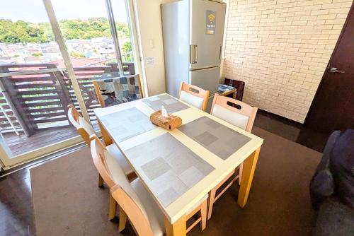 a table and chairs in a room with a large window at 横浜 JS HOUSE Yokohama - ペット犬可 in Yokohama