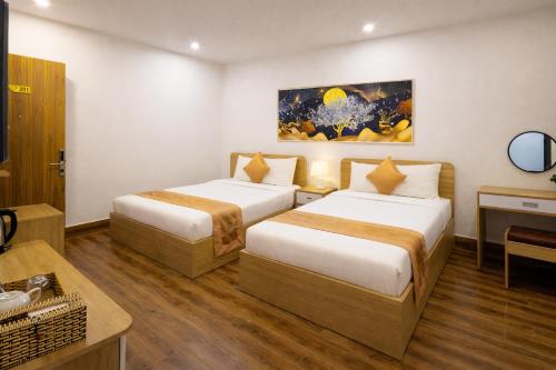 a hotel room with two beds and a table at ROMANCE HOTEL DALAT in Da Lat