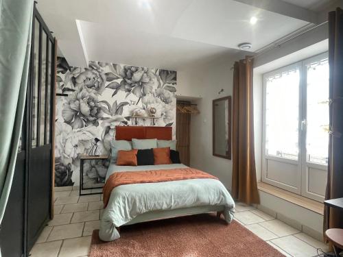 a bedroom with a bed with a floral wallpaper at Le Cosy 8km du futuroscope in Beaumont