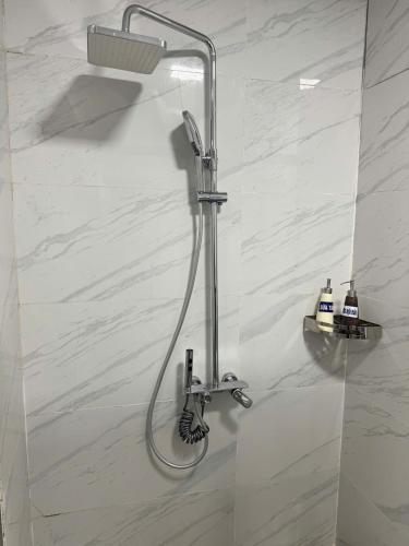 a shower with a shower head in a bathroom at Glory House in An Khê