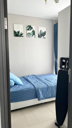 a bedroom with a bed with blue sheets and pictures at Sky High City View 2BR Corner Condomonium in Pulau Sembakau Kecil