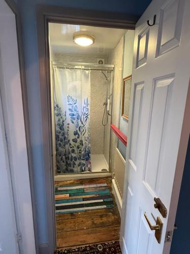 a walk in shower in a bathroom with a door at Crofton House in Yarm
