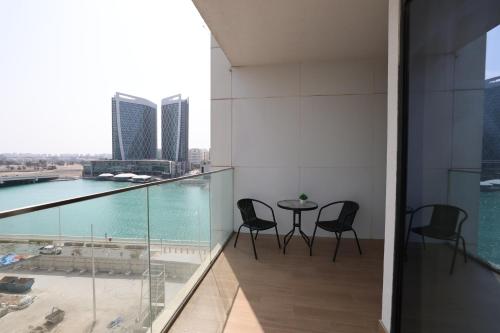a balcony with chairs and a table on a building at Maryah Island 1 Bed Junior Next to Cleveland Hospital by Central Stay in Abu Dhabi
