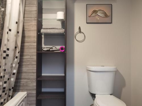 a bathroom with a toilet and a shelf with towels at Suite! Separate Entry, 1 Parking in Newmarket