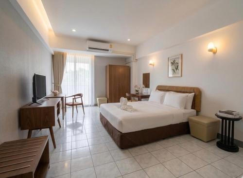 a hotel room with a bed and a desk at Win Mansion in Bangkok