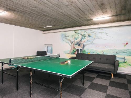 a room with a ping pong table and a couch at 4 person holiday home on a holiday park in Hejls in Hejls