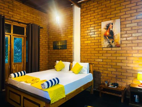 a bed in a room with a brick wall at Sigiriya Dream Inn in Sigiriya