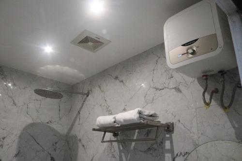 a bathroom with a white towel dispenser on a wall at Edu HOTEL Y-SKANAM SYARIAH in Surabaya