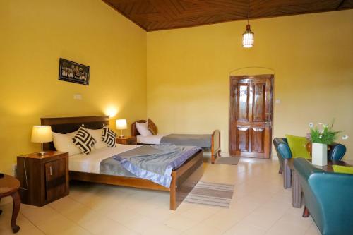 a bedroom with a bed and a couch in a room at Grosvenor Hotel in Nuwara Eliya