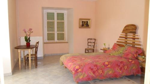 a bedroom with a bed and a table and chairs at Gîte de Très Bayard in Saint-Claude