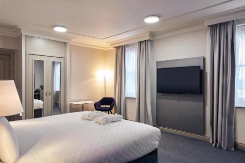 a hotel room with a bed and a flat screen tv at Exeter Rougemont Station Experience By Palette Resorts in Exeter