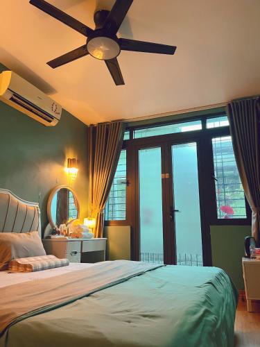 a bedroom with a bed with a ceiling fan at Êm Tiny in Hai Phong
