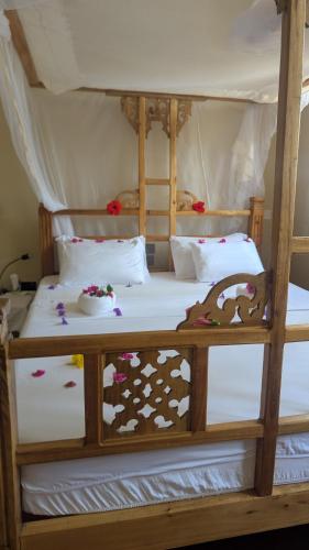 a bedroom with two bunk beds with white sheets at kua garden cottage in Utende
