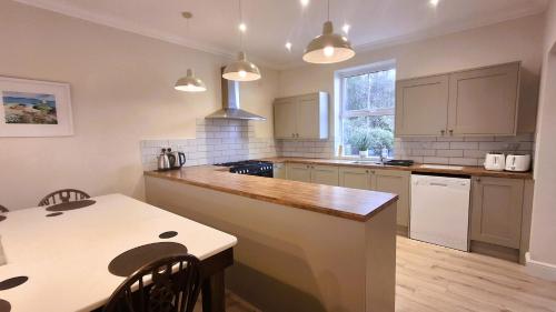 a kitchen with a counter and a table with chairs at Woodlands in Benllech