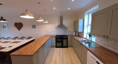 a large kitchen with wooden counter tops and a stove at Woodlands in Benllech