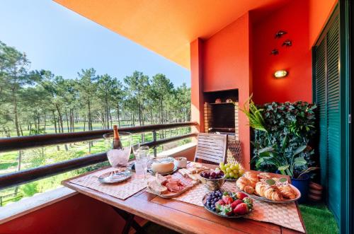 a table with bread and fruit on a balcony at Oasis of Aroeira Golf & Beach House in Aroeira