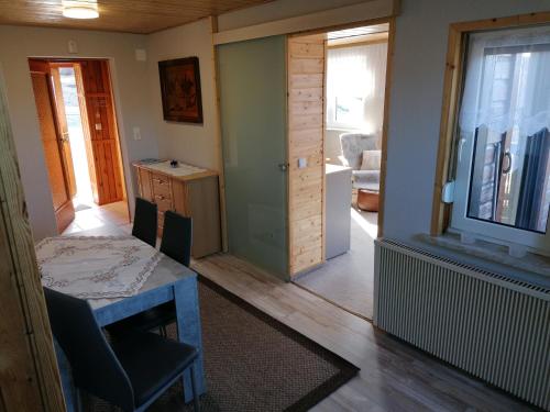 a living room with a table and a door to a kitchen at Ferienhaus Lisa in Klingenthal
