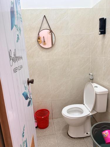 a bathroom with a toilet and a mirror on the wall at The Heaven Luxe Pangandaran in Pangandaran