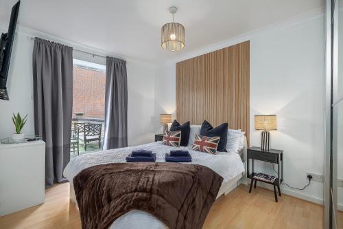 a bedroom with a large bed and a balcony at Cosy 2 BDR flat 5 min to ExCel free Car Parking in London