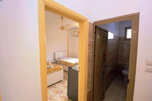 a small room with a bathroom with a bed and a toilet at mountain Luxor in Al Aqālitah