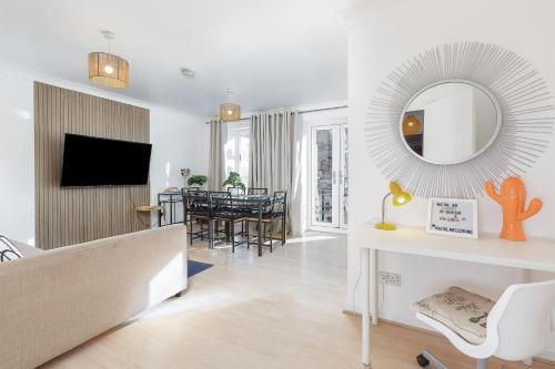 a living room with a couch and a mirror at Cosy 2 BDR flat 5 min to ExCel free Car Parking in London