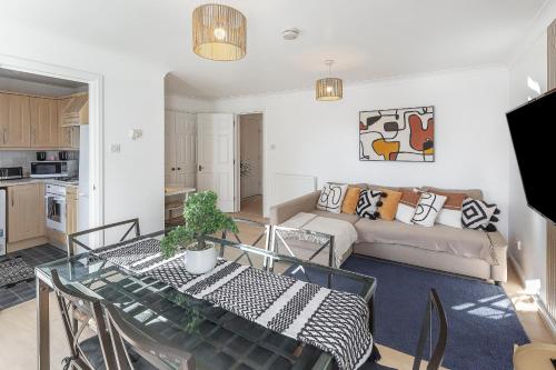 a living room with a table and a couch at Cosy 2 BDR flat 5 min to ExCel free Car Parking in London