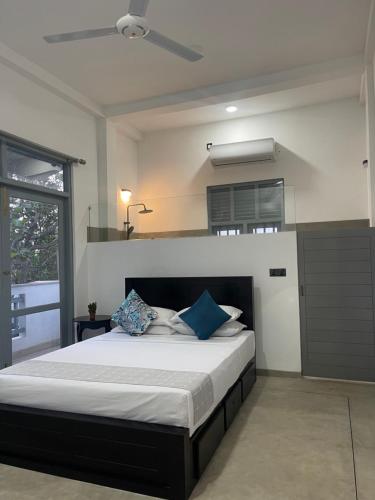 a bedroom with a large bed with blue pillows at Far view villa in Galle