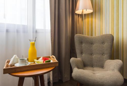 a room with a chair and a table with a vase at Frontier Hotel Rivera in Rivera