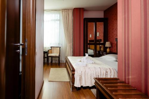 a bedroom with a bed with a white towel on it at Acapulco Hotel in Ploieşti