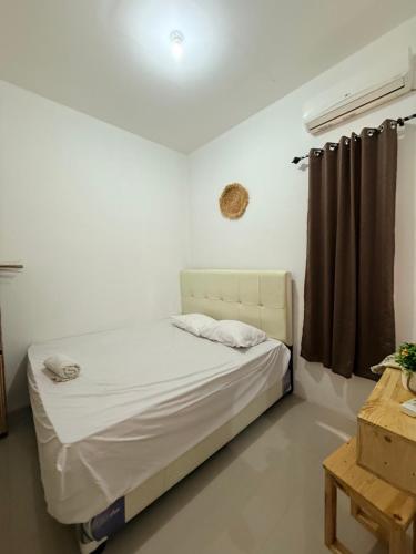 a small bedroom with a bed with a window at The Heaven Luxe Pangandaran in Pangandaran