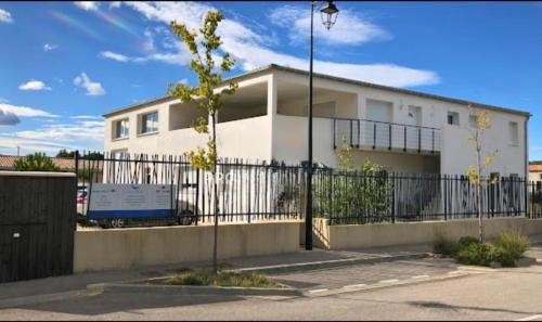 une maison blanche avec une clôture devant dans l'établissement La terrasse, à Charleval
