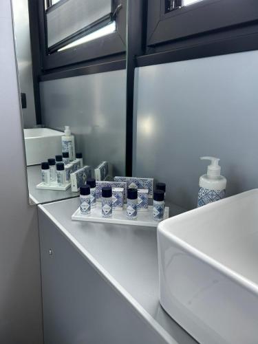 a white counter with glasses and bottles on a shelf at Celesia SKy Water Andromeda in Sesto Calende