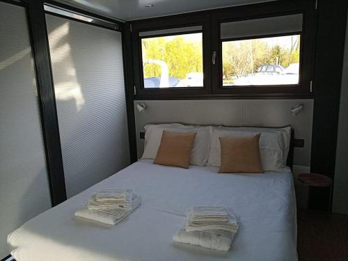 a bedroom with a white bed with two towels on it at Celesia SKy Water Andromeda in Sesto Calende