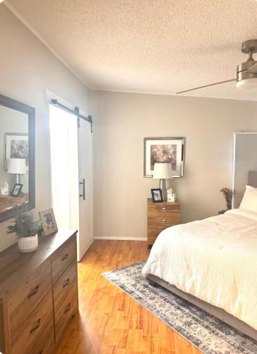 a bedroom with a bed and a dresser and a mirror at Flossies in Seabrook