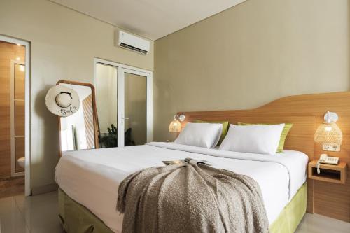 a bedroom with a large bed with white sheets at Deva Bali Apartement in Kerobokan