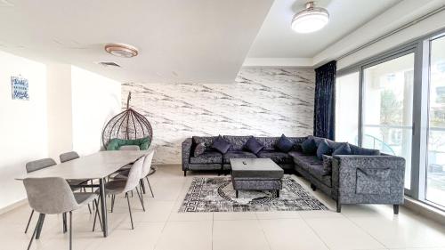 a living room with a couch and a table at Elegant 2 Bedroom Duplex Apartment Pacific Al Marjan Island in Ras al Khaimah