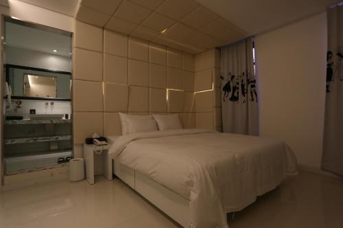 a bedroom with a large bed and a mirror at Christie Hotel 크리스티 호텔 in Seoul