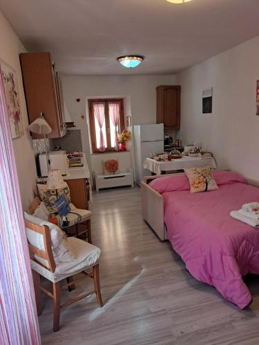a room with two beds and a living room with a kitchen at La Casetta di Mimmi in Castel Viscardo