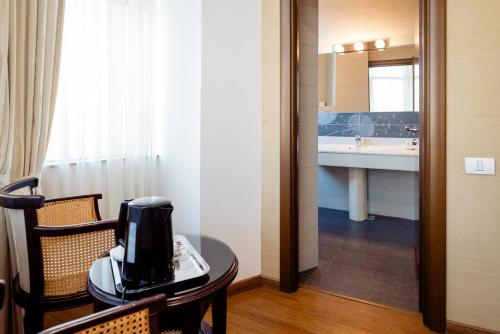a room with a table and a bathroom with a sink at Acapulco Hotel in Ploieşti