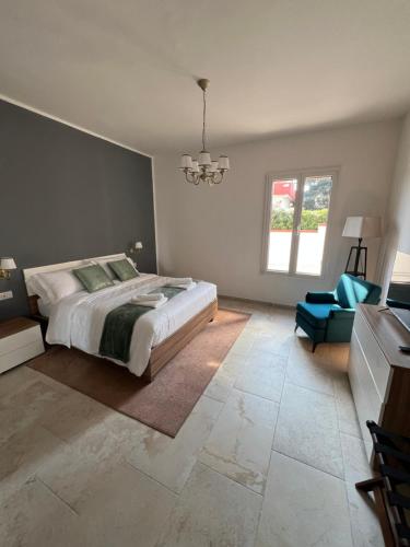 a bedroom with a large bed and a blue chair at Independent Apartments in Modugno in Modugno