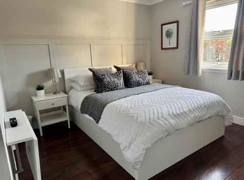 a bedroom with a white bed and a window at Holly Lodge - 2 x Kingsize bedrooms with private entrance and free parking-new shower room in Oban