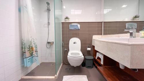 a bathroom with a toilet and a sink at Elegant 2 Bedroom Duplex Apartment Pacific Al Marjan Island in Ras al Khaimah