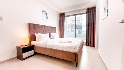 a bedroom with a bed and a large window at Elegant 2 Bedroom Duplex Apartment Pacific Al Marjan Island in Ras al Khaimah