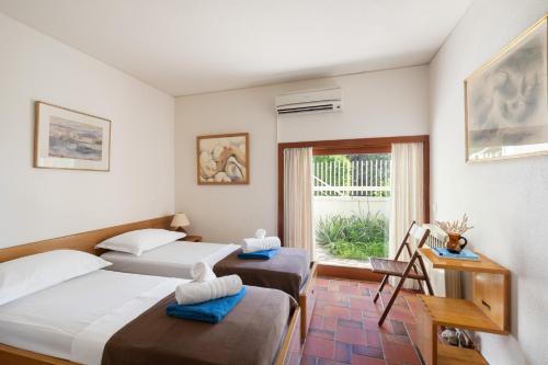 a hotel room with two beds and a window at Villa KATHERINA G in Schinias
