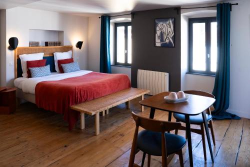 a bedroom with a bed and a table and chairs at La Tour Grégoire in Clermont-Ferrand