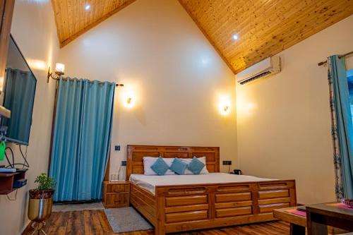 a bedroom with a bed and blue curtains at The Bougainvillea Retreat in Dehradun