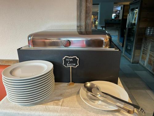 a pile of plates and spoons on a table at Hotel Fortini in Madonna di Campiglio