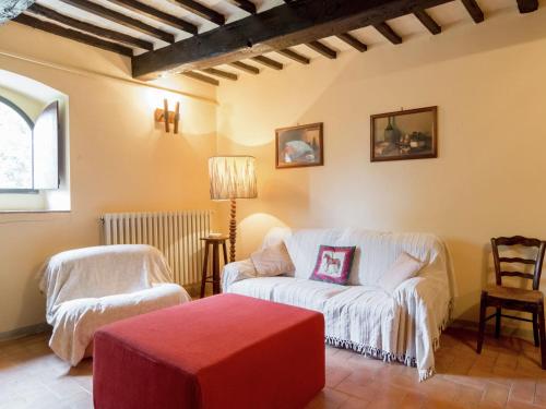 - un salon avec un canapé blanc et un pouf rouge dans l'établissement Belvilla by OYO Il Camino, à Monterchi