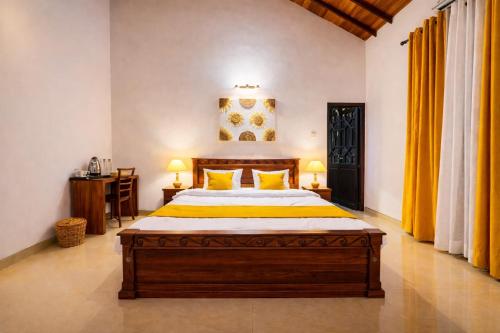 a bedroom with a large wooden bed with yellow pillows at The Green Escape in Miriswatta