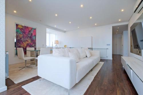 a living room with a white couch and a dining room at Luxury Duplex in Benfica 15 Min to Airport in Lisbon